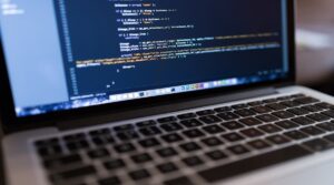 A person working on their laptop, coding for a website to show how long does seo take to work